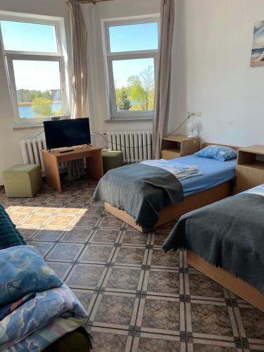 a bedroom with two beds and a desk with a laptop at Rybitwa in Dziwnów