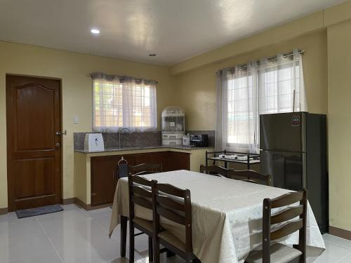 a kitchen with a table with chairs and a refrigerator at Astra Bella Apartment - Unit 2 in Dumaguete