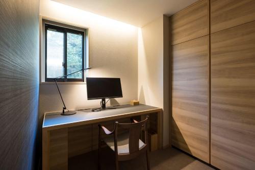 a room with a desk with a computer and a window at Kinzan in Kobe