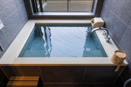 a bath tub with water in it in a bathroom at Kinzan in Kobe