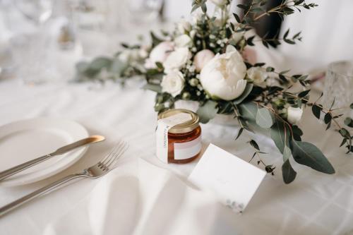 a table with a jar of honey and a vase of flowers at Hotel des Glücks - Landhotel Fischl in Sankt Oswald