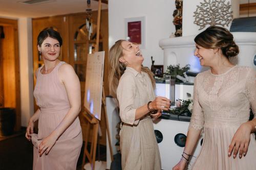 a bride laughing with her bridesmaids at Hotel des Glücks - Landhotel Fischl in Sankt Oswald