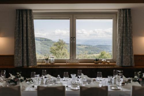 a dining room with a table and a large window at Hotel des Glücks - Landhotel Fischl in Sankt Oswald