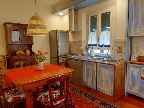 eine Küche mit blauen Schränken und einem Holztisch in der Unterkunft Appartamento Teresina in Marciana Marina
