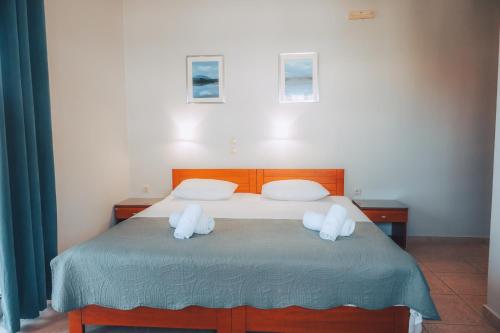 a bedroom with a bed with two white pillows at Dionysos Rooms in Olympiaki Akti