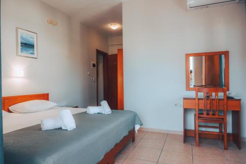 a hotel room with two beds and a television at Dionysos Rooms in Olympiaki Akti