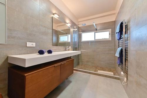 une salle de bain avec un lavabo et une douche dans l'établissement Appartement vue mer aux sanguinaires - stationnement et ascenseur, à Ajaccio