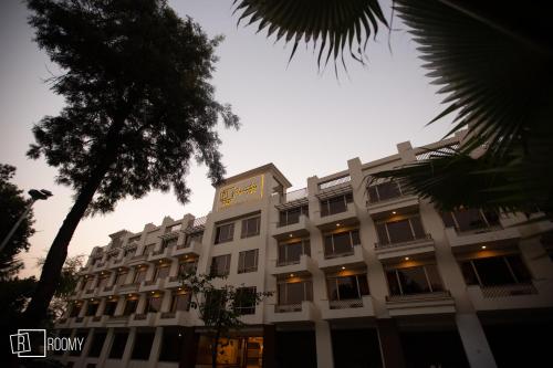 a large white building with a clock on it at Roomy Signature Hotel, Islamabad in Islamabad