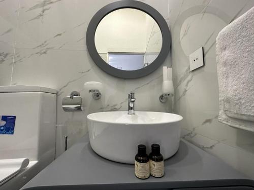 a white bathroom with a sink and a mirror at Hotel ROUTE 62 in Zaqatala