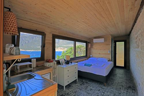 ein Schlafzimmer mit einem Bett und einem Waschbecken in einem Zimmer in der Unterkunft Muhteşem deniz manzaralı ağaç ev in Kaş
