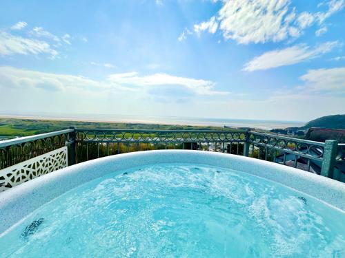 a hot tub on a balcony with a view at The Mermaids Watch Pendine DOG FRIENDLY in Pendine