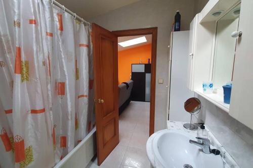 a bathroom with a sink and a shower curtain at Precioso ático en Playa América a 200 metros de la playa in Nigrán