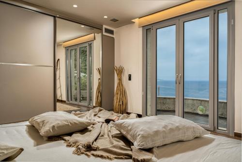 1 dormitorio con 1 cama y vistas al océano en Nefeli Luxury Residence en Marathias