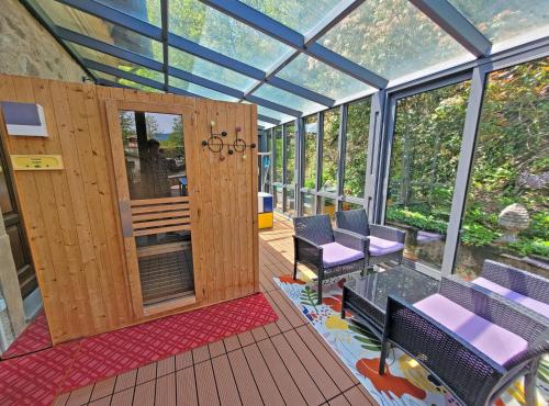 a glass house with purple chairs and windows at Villa Morelli Gualtierotti in Pontepetri