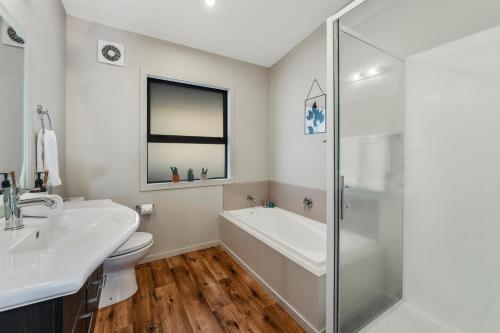 a bathroom with a tub and a sink and a toilet at If I can dream in Taupo