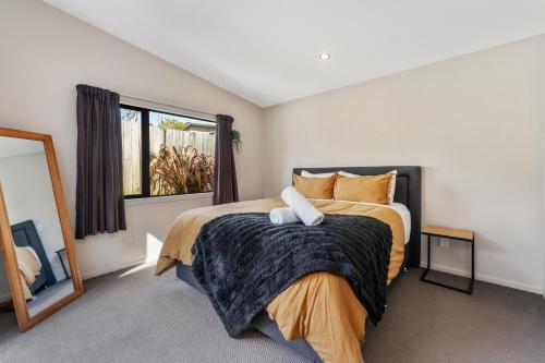 a bedroom with a bed and a large window at If I can dream in Taupo