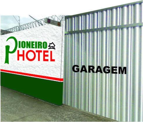 a sign for a hotel next to a garage at Pioneiro Hotel in Teixeira de Freitas