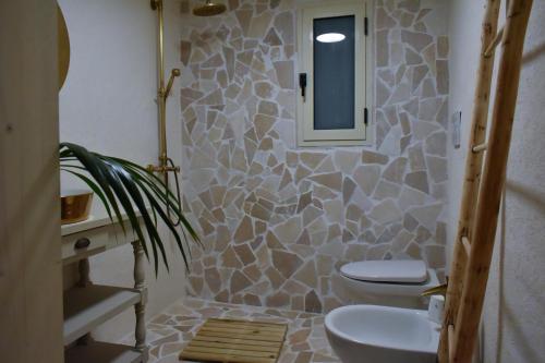 ein Badezimmer mit 2 WCs und einem Spiegel in der Unterkunft Terre d'amore - For couples in Ostuni