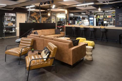 - un salon avec un canapé et des chaises dans un magasin dans l'établissement Auberge de Jeunesse Charleroi Youth Hostel, à Charleroi