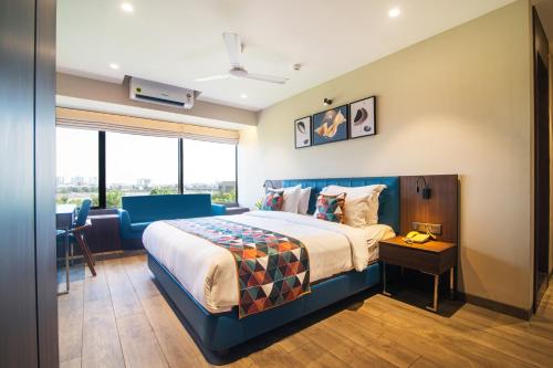 a hotel room with a bed and a desk at Hotel Sadbhav Villa in Surat