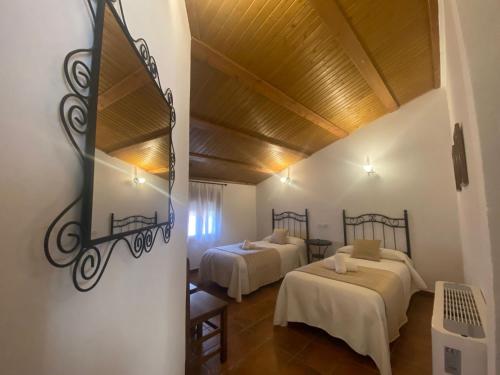 una stanza con due letti in una stanza di Casa Rural del Pantano 4 Estrellas a Buenache de Alarcón