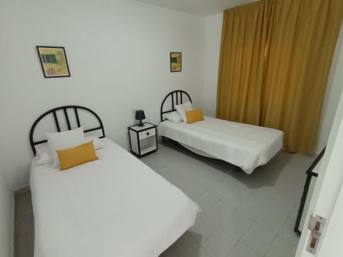 een kamer met 2 bedden en een nachtkastje met 2 meubels bij Molino de Guatiza in Costa Teguise
