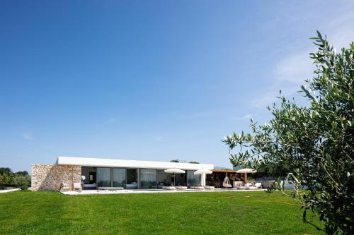 ein Haus mit Rasen davor in der Unterkunft Cresto Iconic Villa, with Heated Spa Whirlpool, By ThinkVilla in Angeliana
