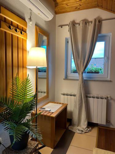 ein Wohnzimmer mit einem Tisch und einem Fenster in der Unterkunft Apartments Zafran in Smoljanac