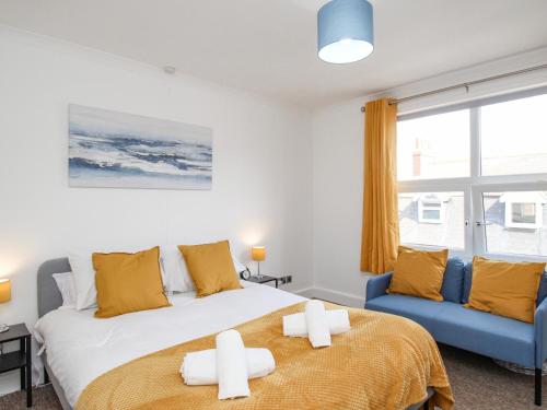 sypialnia z łóżkiem i niebieską kanapą w obiekcie Stones Throw w mieście Weymouth