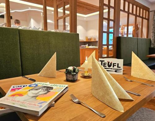 a wooden table with paper boats on top of it at Hotel des Glücks - Landhotel Fischl in Sankt Oswald