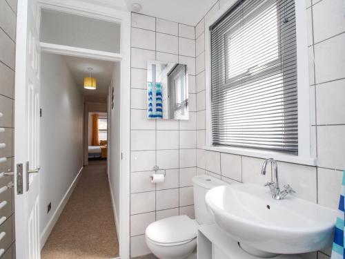 uma casa de banho branca com um WC e um lavatório em Stones Throw em Weymouth