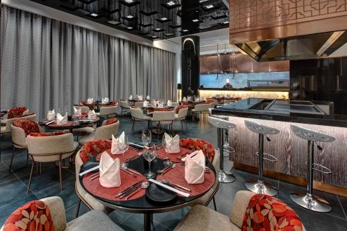a restaurant with tables and chairs and a bar at Royal M Al Aqah Beach Resort by Gewan in Al Aqah