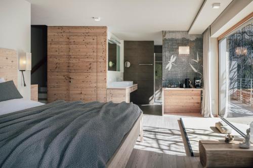 1 dormitorio con 1 cama grande y baño en SILENA, your soulful hotel en Valles