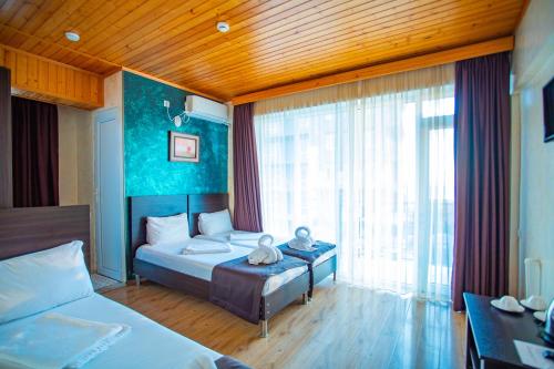 a bedroom with two beds and a large window at Beach House in Batumi