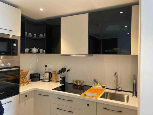 a kitchen with black and white cabinets and a sink at Solaris Premium Luxury Living in Accra
