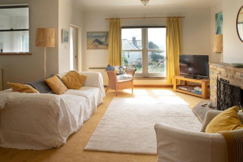 3 Linkside, Thurlestone, South Devon, family home close to the beach في ثورليستون: غرفة معيشة بها كنبتين وتلفزيون