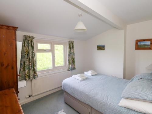 a bedroom with a bed and a window at Siesta Chalet in Bridport