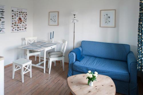 a living room with a blue couch and a table at Ferienwohnung im Haus am See in Klein Upahl