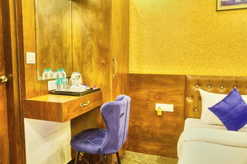 a bedroom with a blue chair and a bed at SM Royal Stay Hotel - Near Bangalore international Airport in Bengaluru