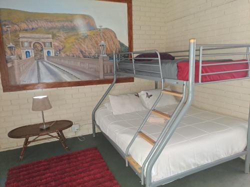 a room with two bunk beds and a table at Shangrila-innibos Country Lodge in Hartbeespoort
