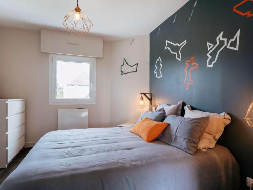 une chambre avec un grand lit avec des oreillers orange dans l'établissement Carnac : Duplex 3 pièces avec Piscine Chauffée, Wifi et Parking, à 1 km de la Plage - FR-1-477-149, à Carnac