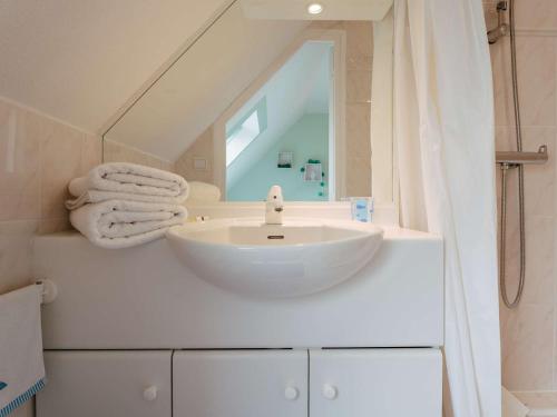 une salle de bain avec un lavabo blanc et un miroir dans l'établissement Carnac : Duplex 3 pièces avec Piscine Chauffée, Wifi et Parking, à 1 km de la Plage - FR-1-477-149, à Carnac