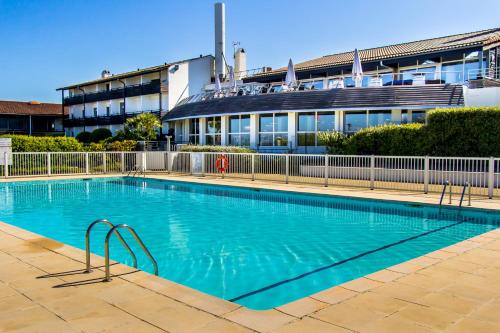 ein großes Schwimmbad vor einem Gebäude in der Unterkunft Village Vacances Azureva Anglet in Anglet