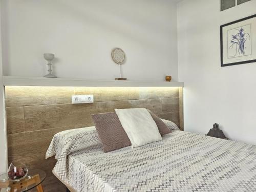 een slaapkamer met een bed met een houten hoofdeinde bij HOLIDAYS CITY CENTER, Los Cristianos Beach in Arona