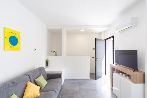 a living room with a couch and a tv at KHL APARTMENTS - SanSiro, Milano in Milan