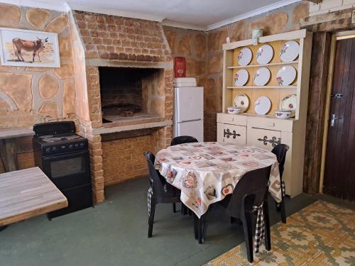 a kitchen with a table and a stove and a fireplace at Shangrila-innibos Country Lodge in Hartbeespoort