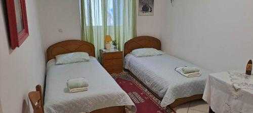 a bedroom with two beds and a table and a window at Loula's House in Spetses