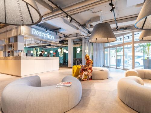 a woman sitting in the lobby of a store at ibis Styles Graz Messe in Graz