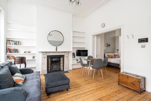 sala de estar con sofá y chimenea en JOIVY Chic flat with private terrace near Kensington Palace, en Londres