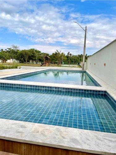 a swimming pool with blue tiles on top of it at Ap Remanso - Cond Lençois Confort Barreirinhas in Barreirinhas